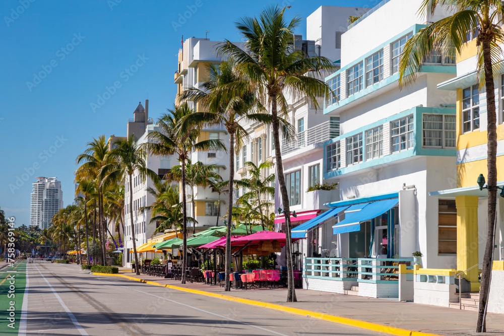 Fototapeta premium Ocean Drive in Miami Beach Florida is one of the most widely known streets in America for its historic landmark art deco buildings along the Atlantic Ocean with street closed to traffic