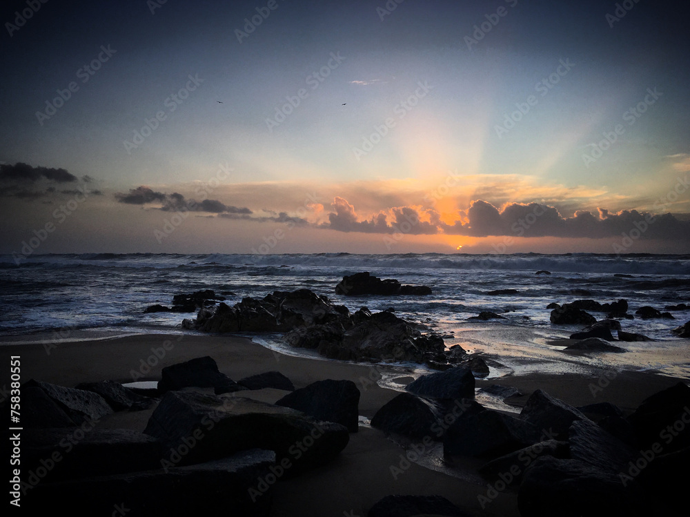 Last rays of the sunset over the rocky coast of the Atlantic Ocean near Miramar, Arcozelo, Porto, Portugal, January 2018