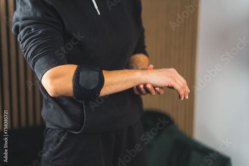 a person in sportswear using an elbow support brace, closeup shot, injuries and healing. High quality photo