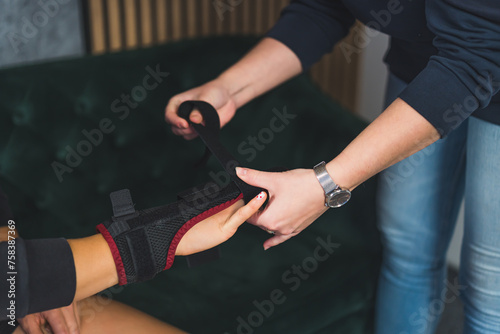 a person wrapping a splint on the other person's middle finger at home. High quality photo