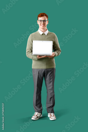 Young business owner with laptop on green background © Pixel-Shot