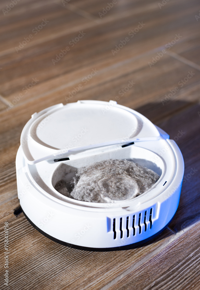 Fototapeta premium Robot vacuum cleaner in a modern living room on the floor. Smart vacuum cleaner in a smart home