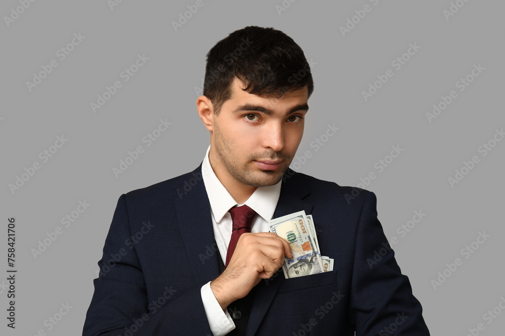 Young businessman with bribe in pocket on light background, closeup Young businessman with bribe in pocket on light background, closeup