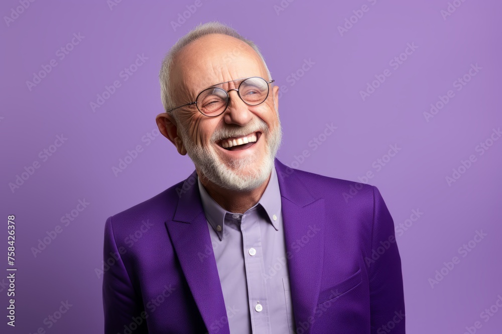 Portrait of a happy senior man in a purple suit and glasses. Isolated over purple background.