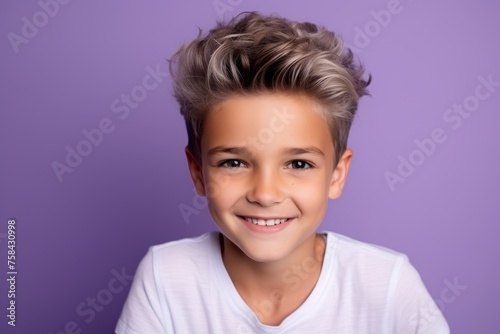 Portrait of a smiling little boy with blond hair on violet background