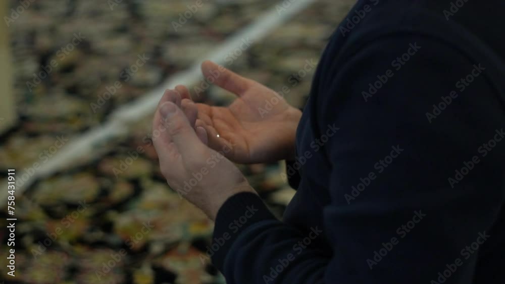 Man praying to God with open hands in mosque Man praying to God with open hands in mosque