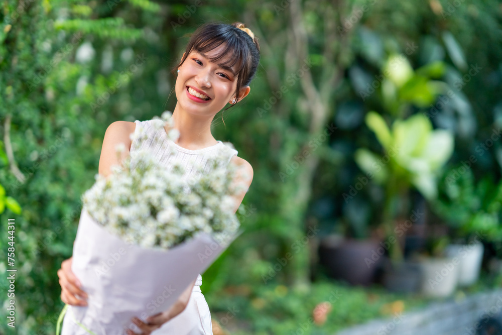 Portrait of Happy young Asian woman holding flowers bouquet in the garden in springtime. Attractive girl enjoy and fun outdoor lifestyle shopping in the city on summer holiday vacation. Portrait of Happy young Asian woman holding flowers bouquet in the garden in springtime. Attractive girl enjoy and fun outdoor lifestyle shopping in the city on summer holiday vacation.