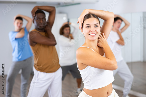 Canvas Print Portrait of cheerful female training position of hands before pair dance in mode