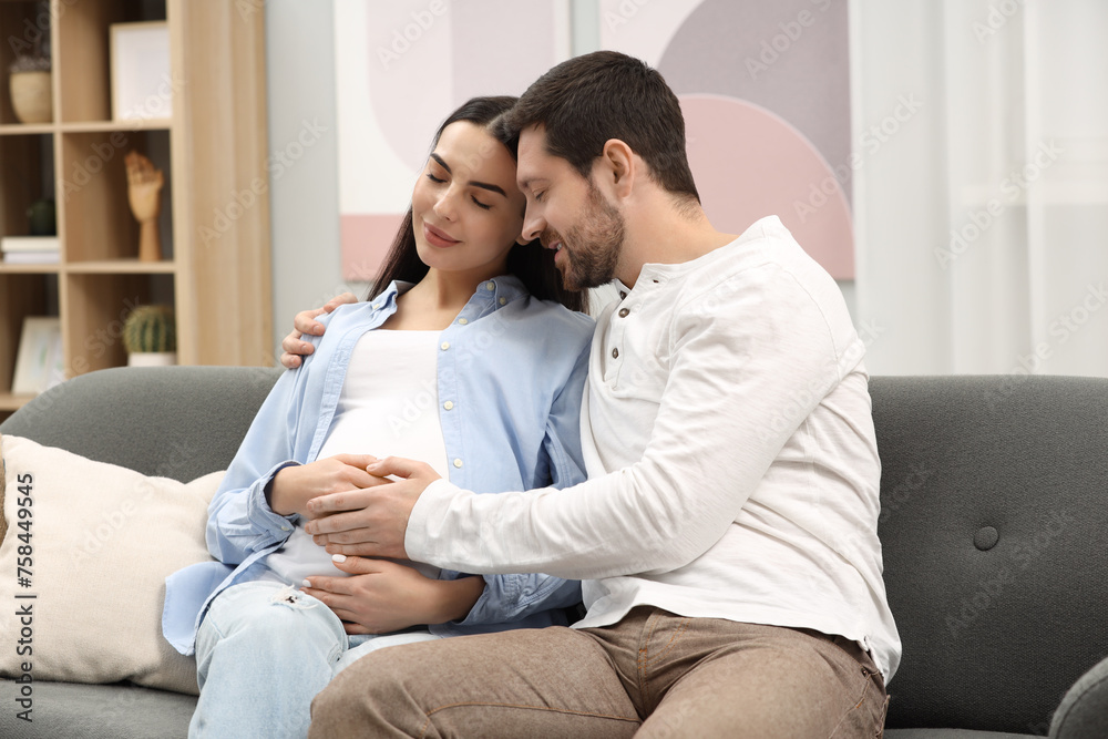 Pregnant woman with her husband on sofa at home Pregnant woman with her husband on sofa at home