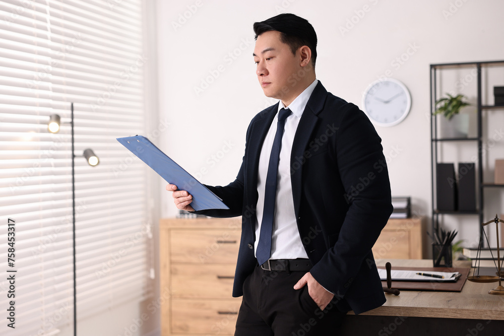 Portrait of confident notary with clipboard in office Portrait of confident notary with clipboard in office