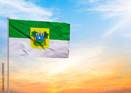 3D illustration of a Rio Grande do Norte flag extended on a flagpole and in the background a beautiful sky with a sunset