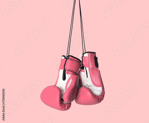 Breast cancer. Pair of pink boxing gloves on color background © New Africa