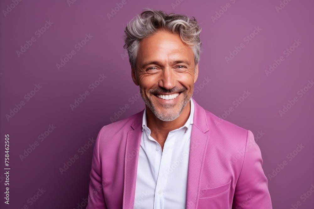 Portrait of a handsome mature man smiling and looking at camera against purple background Portrait of a handsome mature man smiling and looking at camera against purple background