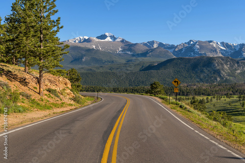 U.S. Route 36 in RMNP - A Spring evening view of winding Highway 36, with snow-capped Longs Peak towering in background, in Rocky Mountain National Park, Colorado, USA.