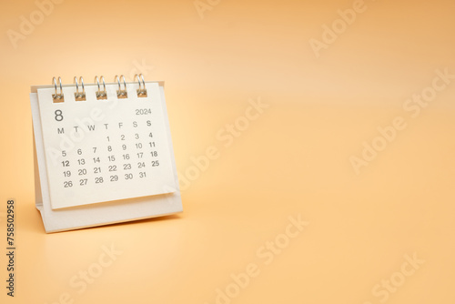 Simple desk calendar for August 2024 isolated on orange background. Calendar concept with copy space.