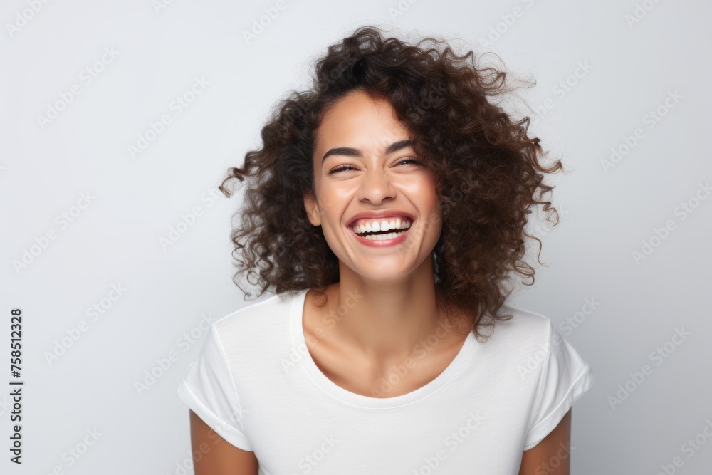 Portrait of beautiful young woman with curly hair smiling and looking at camera