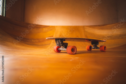 Skateboard on the mini ramp at skate park indoor with brown wooden floor. photo