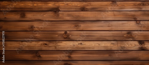 A detailed shot of a brown hardwood plank wall, showcasing the intricate pattern of the wood grain and tints and shades created by the wood stain
