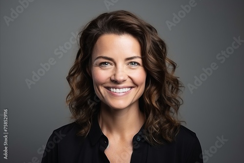 Portrait of a smiling businesswoman looking at camera over grey background