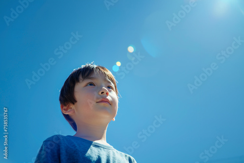 青空を見上げる小学生の男の子 photo