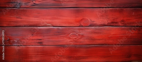 A closeup of a brown wooden rectangle wall with an amber and magenta wood stain. The hardwood flooring has a beautiful pattern of tints and shades