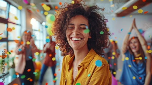 Vivid image of a young woman with curly hair laughing amidst a burst of colorful confetti, with happy people celebrating in the background.
