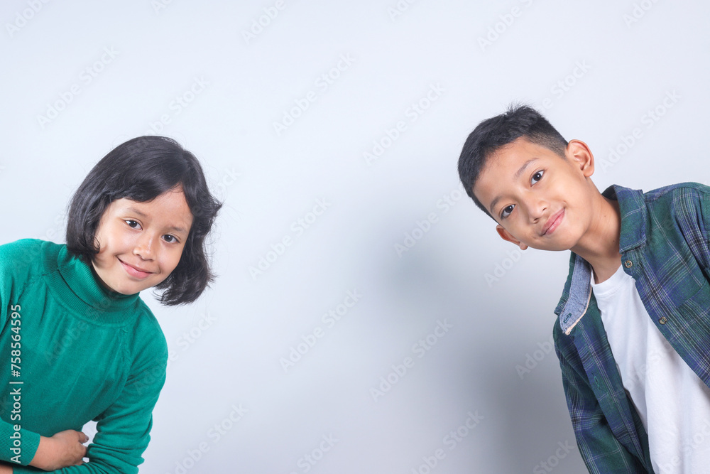 Portrait of cheerful two Asian children with copy space on grey background Portrait of cheerful two Asian children with copy space on grey background