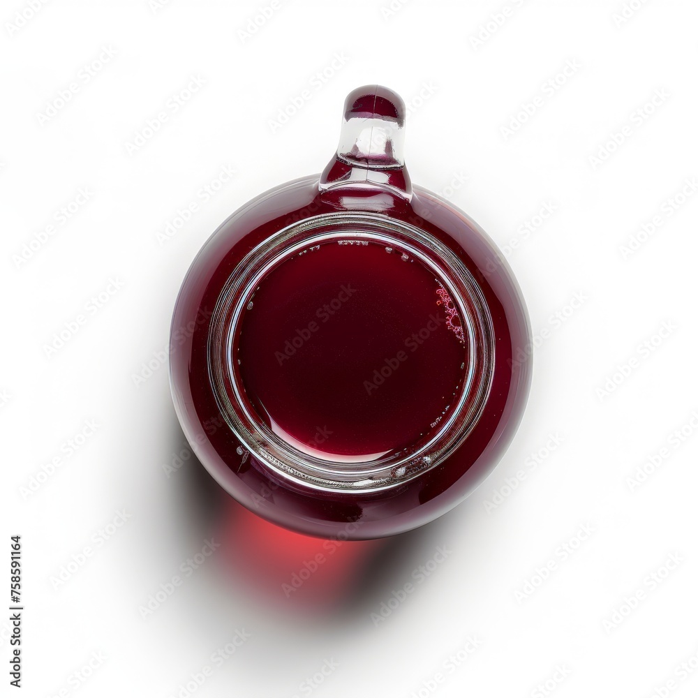 a glas jar filled with grape juice surrounded by red grapes on a white studio background