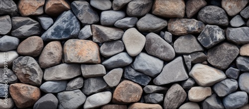 A closeup of a stack of cobblestone rocks, used as building material for walls or road surfaces. The natural pattern of the bedrock creates a unique and durable composite material photo