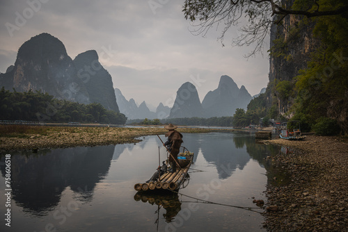 Cormorant fisherman and his bird on the Li River in Yangshuo, Guangxi, China.