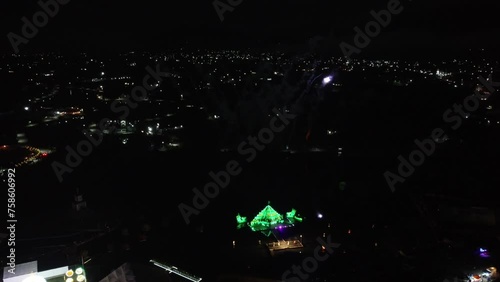 Aerial top down: Firework with explosion at dark night sky of Mexico. Illuminated Pyramid at festival. photo