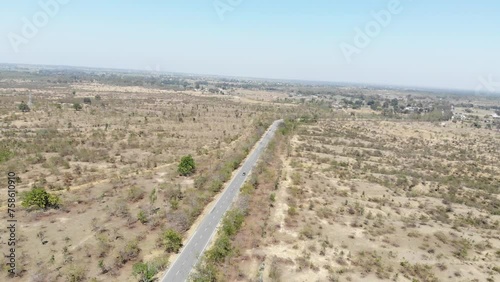 Aerial shot of beautiful vast barren land near Charu village in Chatra, Jharkhand, India with a road passing in the middle and a bike travelling. Jharkhand tourism. photo