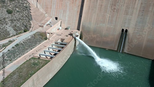 Hydroelectric satation. Gravity dam discharging water. Howell bunger valve in operation.  Dolly out aerial view view over the dam and river. Renewable energies. photo