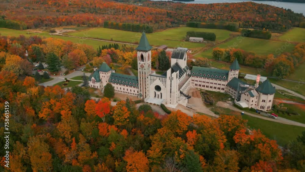 aerial shot around saint benoit du lac abbey at fall with colorful trees near magog on and memphremagog lake in quebec region, autumn season, canada