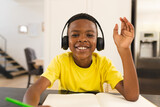 A young African American boy is engaged in a school activity on a video call online school lesson