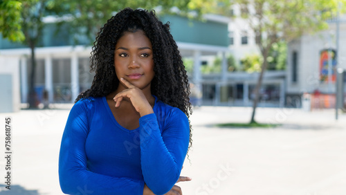 Thinking african american young adult woman with copy space in the city