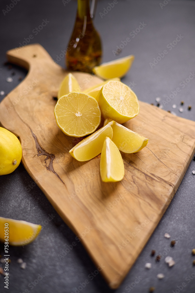 Sliced lemon fruit on a wooden cutting board at domestic kitchen Sliced lemon fruit on a wooden cutting board at domestic kitchen