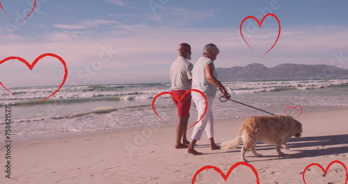 Image of hearts over senior african american couple with dog on sunny beach