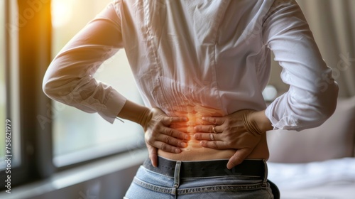  woman holding her lower back while and suffer from unbearable pain health and problems, chronic back pain, backache in office syndrome, scoliosis, herniated disc, muscle inflammation photo