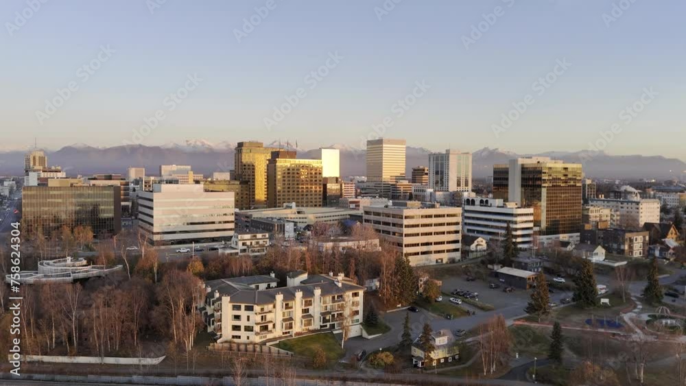 HDR stock drone video of Anchorage city skyline at sunset with warm glow on buildings. Aerial view of Alaskan city moving up and left HDR stock drone video of Anchorage city skyline at sunset with warm glow on buildings. Aerial view of Alaskan city moving up and left