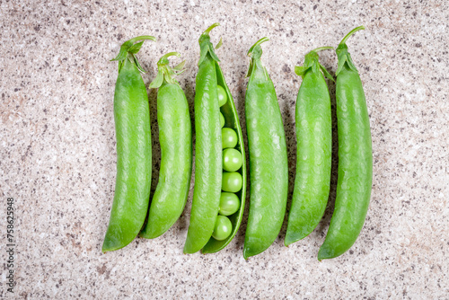 Green peas in pods on a gray table
