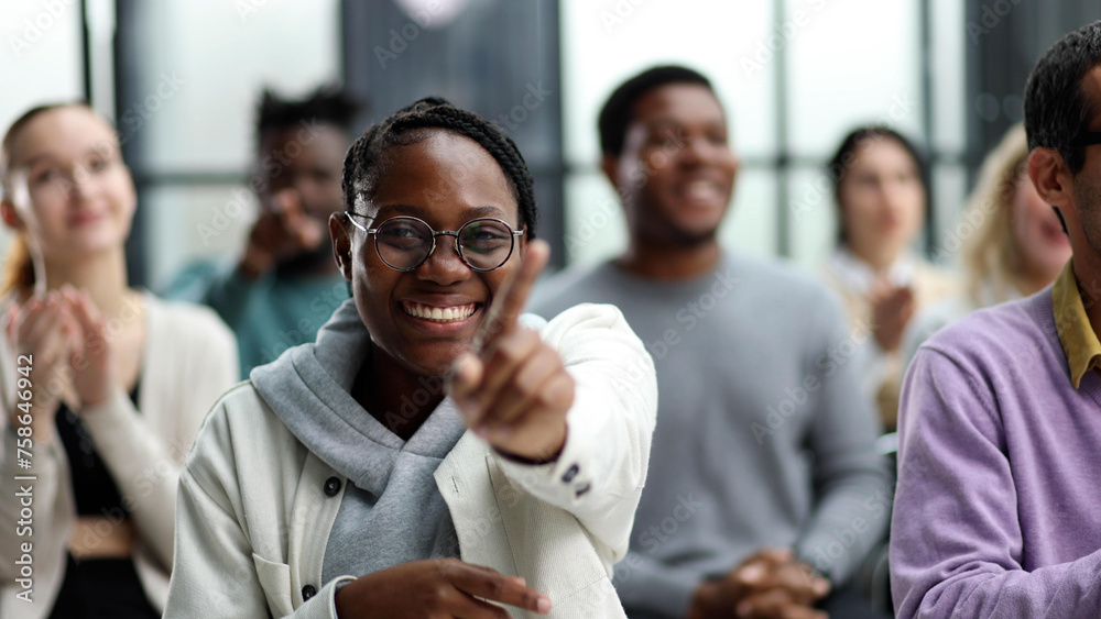Obraz premium smiling african american woman pointing finger at camera.