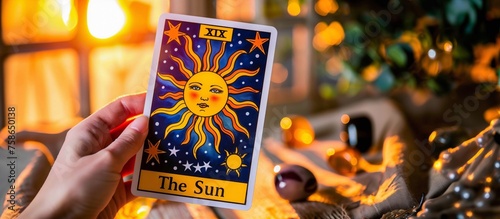 The Sun Tarot Card Displayed with Warm Bokeh Background