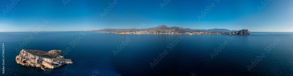 Extremely wide angle panoramic aerial photo of the city of Benidorm in Spain showing a panoramic drone view the whole town from the ocean including the famous Mirador de l'Illa de Benidorm island Extremely wide angle panoramic aerial photo of the city of Benidorm in Spain showing a panoramic drone view the whole town from the ocean including the famous Mirador de l'Illa de Benidorm island