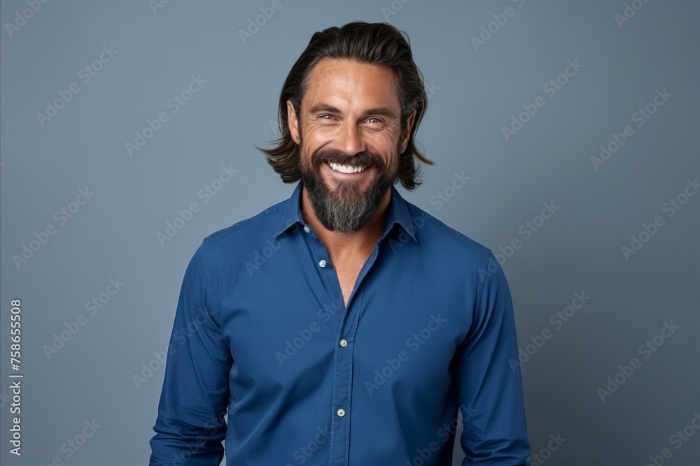 Handsome middle aged man smiling at camera while standing against grey background Handsome middle aged man smiling at camera while standing against grey background