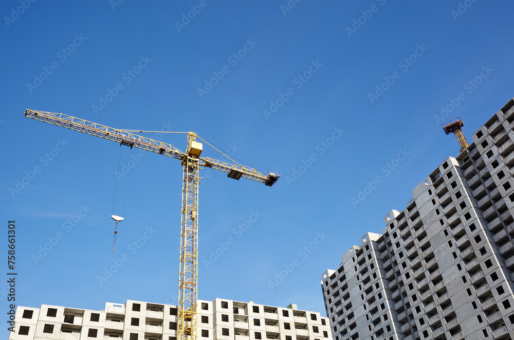 Tower crane building a house. Concrete building under construction. Construction site Tower crane building a house. Concrete building under construction. Construction site