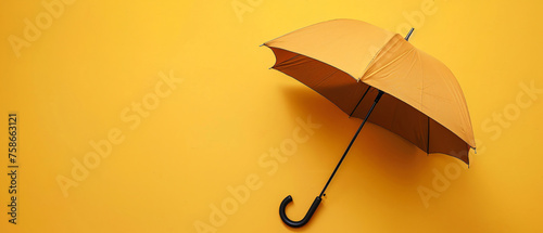 A brown umbrella with a black handle on a yellow background