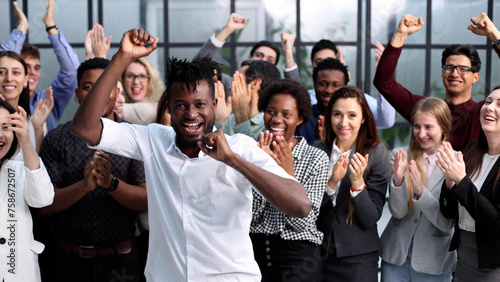 Impressed young coworkers clapping and looking at camera