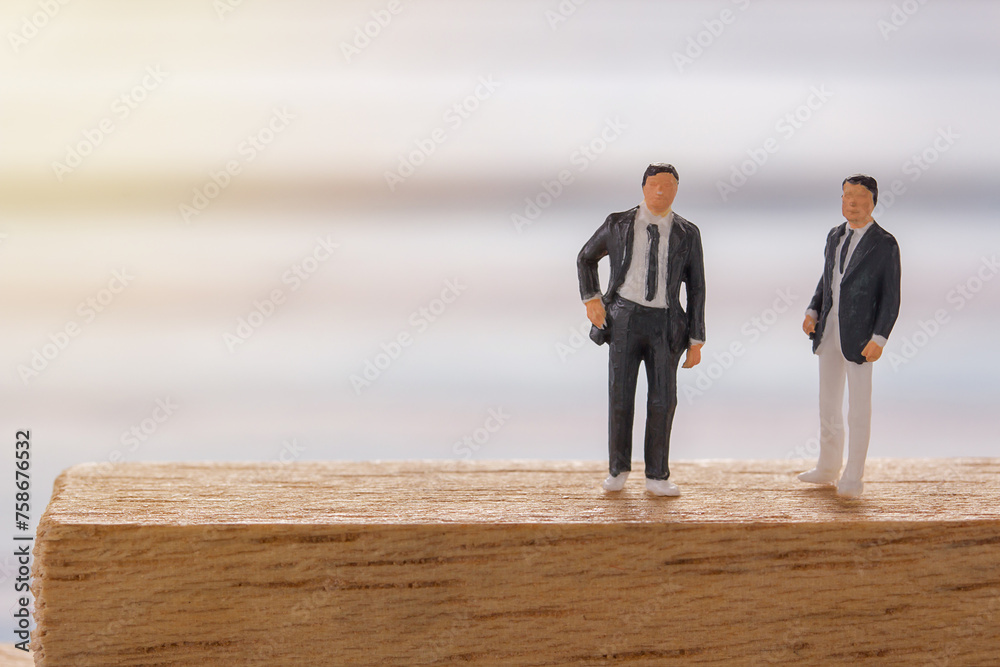 Businessman figures standing on the floor and business negotiations Businessman figures standing on the floor and business negotiations