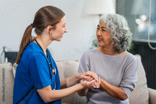 Wallpaper Mural Caucasian female doctor offers encouragement to Asian mature elderly patient woman while holding hands, providing comfort and support during a medical consultation at sofa. Torontodigital.ca